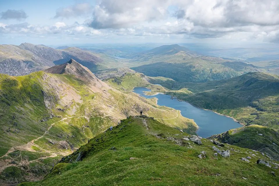 Green ridge below the summit of Yr Wyddfa looking down to Llyn Llydaw, with the pointed top of Crib Goch on the left